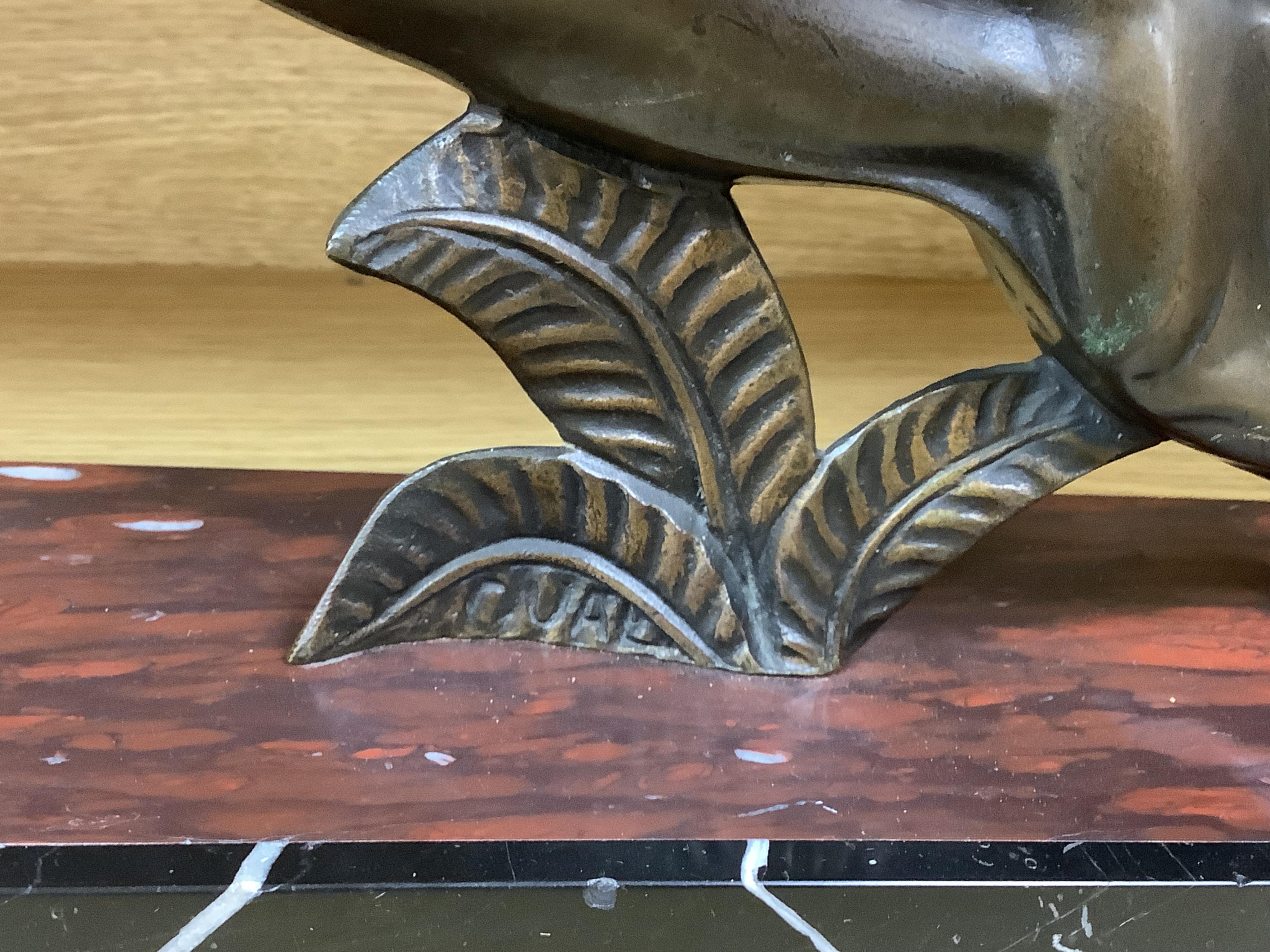A French Art Deco bronze sculpture of a panther, raised on slanted base, 44cm wide
